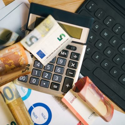 A calculator sitting on top of a pile of money